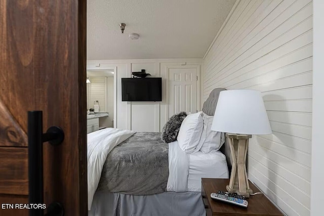 413 Baskins Creek Rd Apt 605, Gatlinburg, TN 37738 - bedroom featuring ensuite bath and a textured ceiling