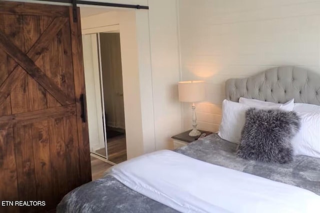 413 Baskins Creek Rd Apt 605, Gatlinburg, TN 37738 - bedroom featuring a barn door and wood finished floors