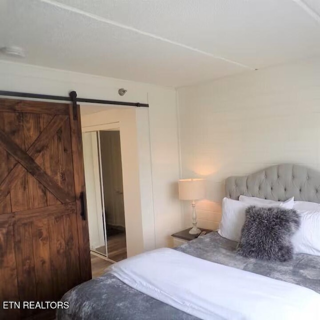 413 Baskins Creek Rd Apt 605, Gatlinburg, TN 37738 - bedroom featuring a barn door and wood finished floors