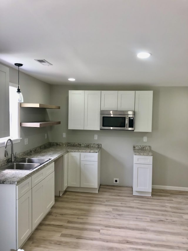 711 Gwen St, Paris, TN 38242 - kitchen featuring stainless steel microwave, a sink, open shelves, white cabinets, and recessed lighting