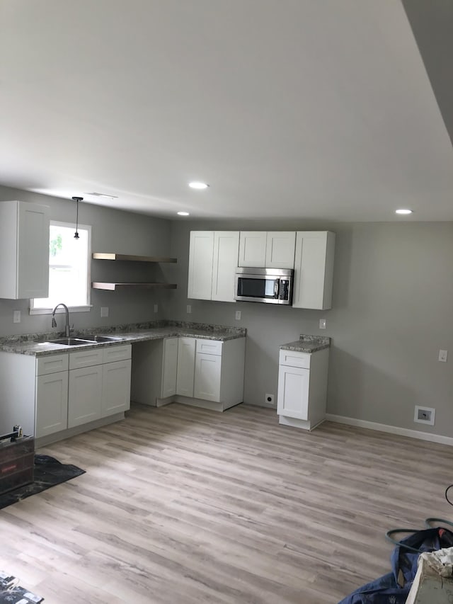 711 Gwen St, Paris, TN 38242 - kitchen featuring stainless steel microwave, open shelves, light wood-type flooring, recessed lighting, and baseboards