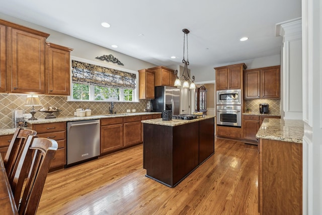 2064 Catalina Way, Nolensville, TN 37135 - kitchen featuring appliances with stainless steel finishes, backsplash, brown cabinets, light wood-type flooring, and recessed lighting