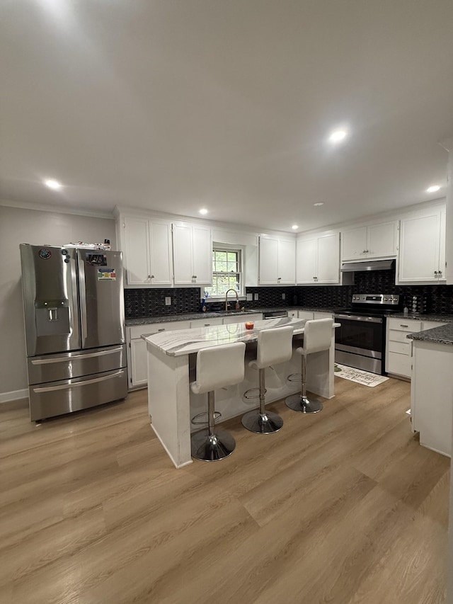 561 Castlegate Dr, Nashville, TN 37217 - kitchen with stainless steel appliances, under cabinet range hood, a kitchen island, decorative backsplash, and recessed lighting