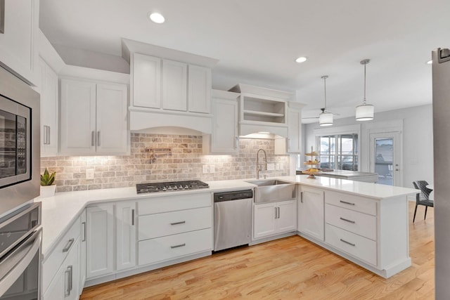 175 Dobson Knob Trl, Nolensville, TN 37135 - kitchen with stainless steel appliances, a peninsula, a sink, backsplash, and white cabinetry