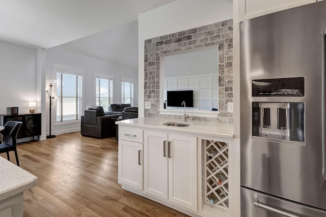 175 Dobson Knob Trl, Nolensville, TN 37135 - kitchen featuring stainless steel refrigerator with ice dispenser, open floor plan, a sink, white cabinets, and light wood-style floors