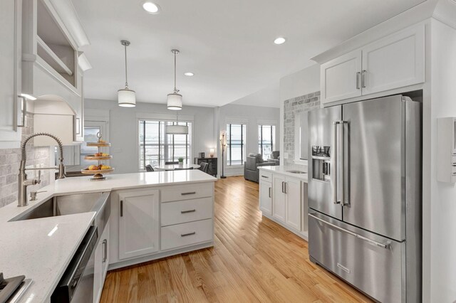 175 Dobson Knob Trl, Nolensville, TN 37135 - kitchen with stainless steel appliances, a sink, a peninsula, white cabinetry, and light wood-style floors