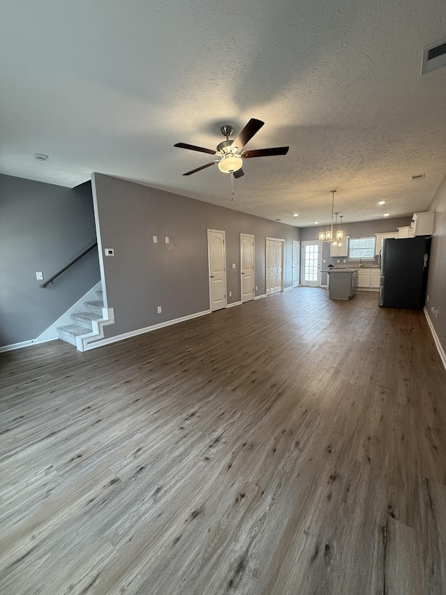 412 Moshe Mualem Pl, La Vergne, TN 37086 - unfurnished living room with a ceiling fan, a textured ceiling, dark wood-style flooring, baseboards, and stairway