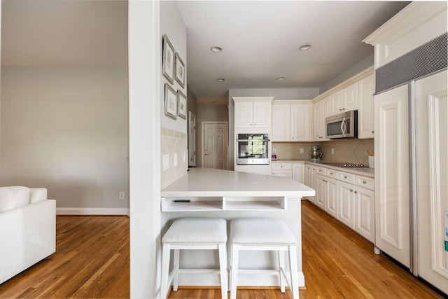 113 Joshuas Run, Goodlettsville, TN 37072 - kitchen featuring appliances with stainless steel finishes, light wood-style floors, a breakfast bar area, backsplash, and recessed lighting