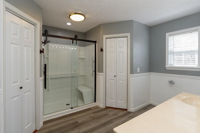 55 Bluebird Ln, Lafayette, TN 37083 - full bathroom featuring a closet, wood finished floors, a stall shower, a wainscoted wall, and vanity