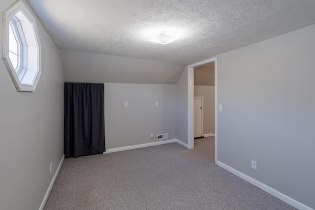 55 Bluebird Ln, Lafayette, TN 37083 - bonus room featuring vaulted ceiling, a textured ceiling, light colored carpet, and baseboards