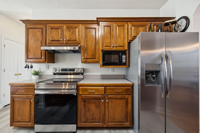 2056 Earl Pearce Cir, Mount Juliet, TN 37122 - kitchen featuring stainless steel appliances, under cabinet range hood, brown cabinetry, light countertops, and light wood-type flooring