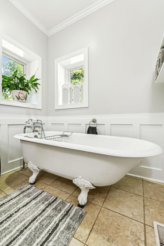 1064 Bills Ln, Joelton, TN 37080 - bathroom with ornamental molding, tile patterned floors, a soaking tub, a decorative wall, and wainscoting