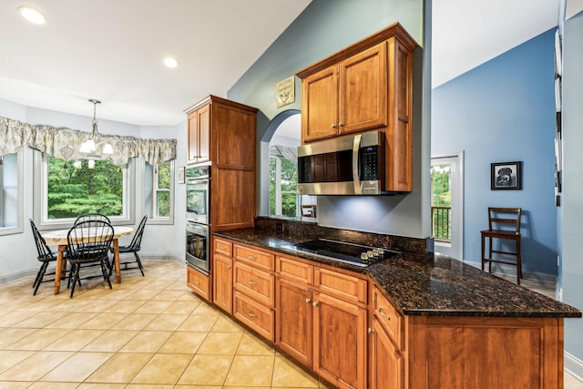 1064 Bills Ln, Joelton, TN 37080 - kitchen featuring stainless steel appliances, a chandelier, light tile patterned floors, brown cabinets, and dark stone countertops