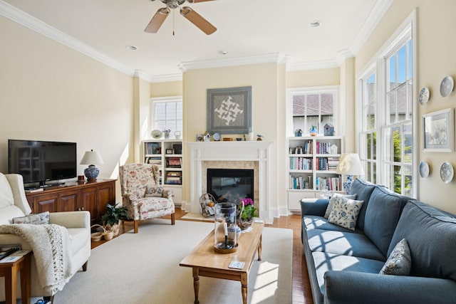 3007 General Martin Ln, Franklin, TN 37064 - living room featuring crown molding, a ceiling fan, wood finished floors, a glass covered fireplace, and built in features