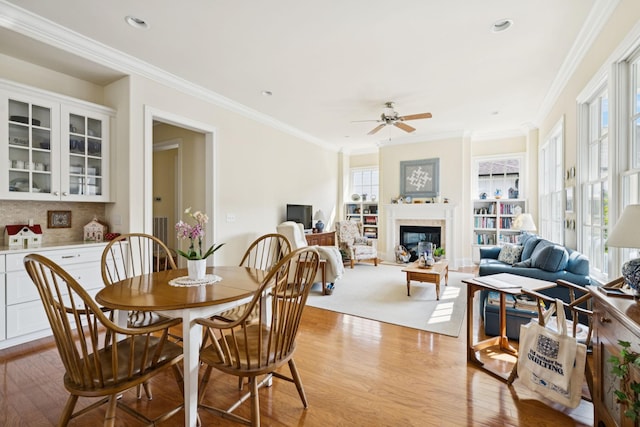 3007 General Martin Ln, Franklin, TN 37064 - dining space with wood finished floors, a ceiling fan, crown molding, a glass covered fireplace, and recessed lighting