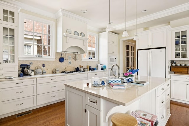 3007 General Martin Ln, Franklin, TN 37064 - kitchen with white appliances, white cabinetry, a center island with sink, dark wood finished floors, and crown molding
