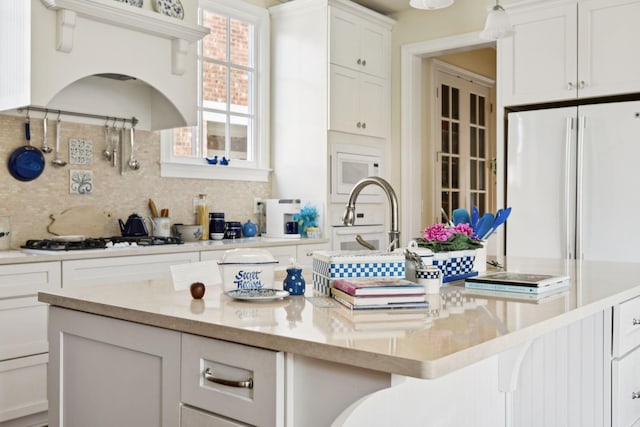 3007 General Martin Ln, Franklin, TN 37064 - kitchen with white appliances, tasteful backsplash, white cabinets, a center island, and a breakfast bar area