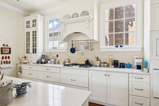 3007 General Martin Ln, Franklin, TN 37064 - kitchen featuring white gas stovetop, ornamental molding, tasteful backsplash, white cabinets, and light countertops