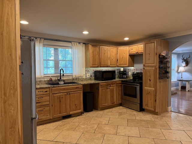 1650 E Beaverdam Rd, Centerville, TN 37033 - kitchen with stainless steel appliances, a sink, arched walkways, tasteful backsplash, and dark stone countertops