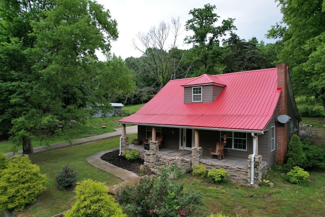 1650 E Beaverdam Rd, Centerville, TN 37033 - view of front of property with metal roof, a chimney, covered porch, a front yard, and a wooded view