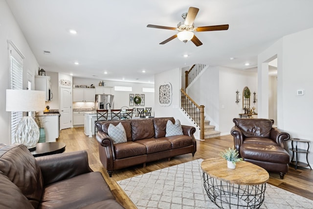 1045 Brayden Dr, Fairview, TN 37062 - living room featuring light wood-type flooring, stairway, a ceiling fan, and recessed lighting