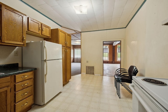 1319 Main St N, Carthage, TN 37030 - kitchen featuring light flooring, brown cabinetry, white appliances, and dark countertops