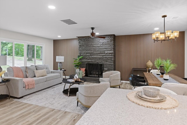 2605 Avalon Hl, Chattanooga, TN 37415 - living room with ceiling fan, a chandelier, light wood finished floors, wooden walls, and an accent wall