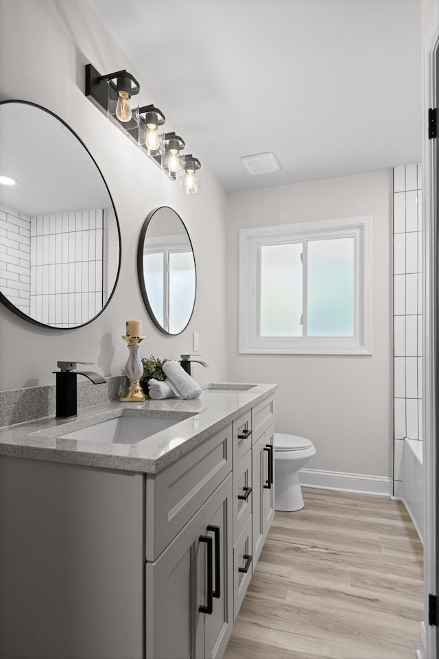 2605 Avalon Hl, Chattanooga, TN 37415 - full bath with double vanity, baseboards, toilet, and wood finished floors