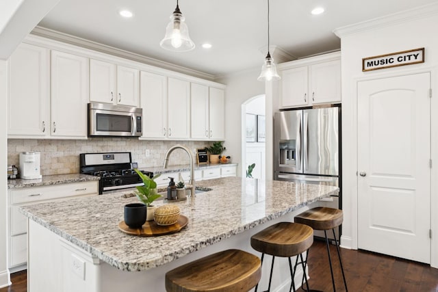 1074 Cantwell Pl, Spring Hill, TN 37174 - kitchen featuring stainless steel appliances, ornamental molding, backsplash, dark wood-style flooring, and arched walkways