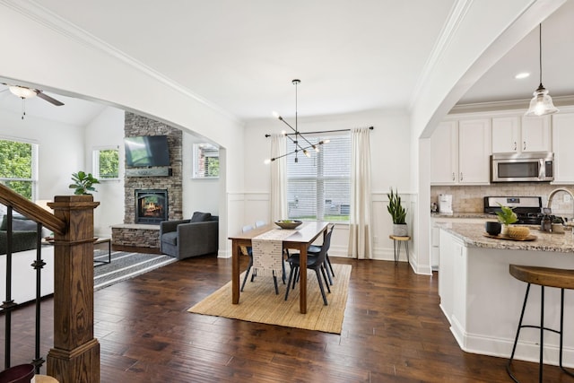 1074 Cantwell Pl, Spring Hill, TN 37174 - dining area with a fireplace, a chandelier, dark wood-type flooring, ornamental molding, and a ceiling fan