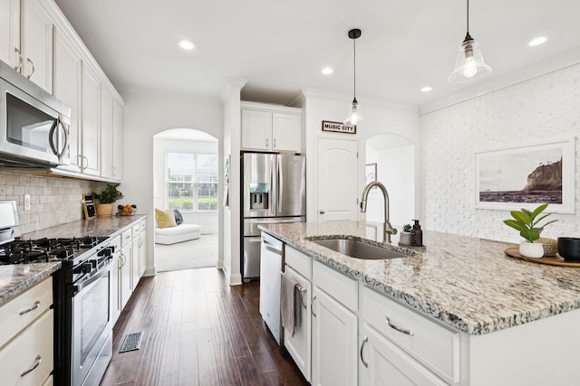 1074 Cantwell Pl, Spring Hill, TN 37174 - kitchen with appliances with stainless steel finishes, arched walkways, a sink, dark wood finished floors, and crown molding