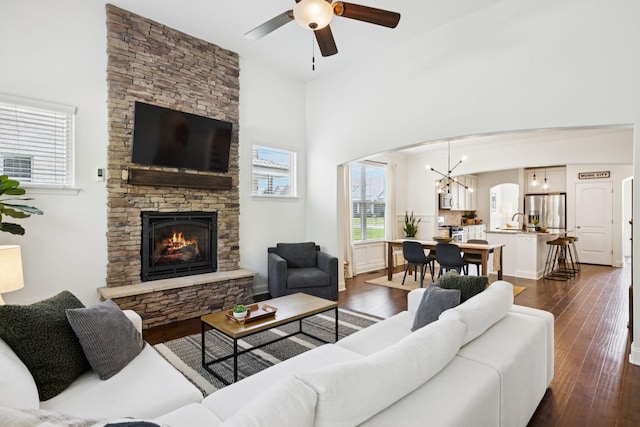 1074 Cantwell Pl, Spring Hill, TN 37174 - living room with dark wood-style flooring, a stone fireplace, a ceiling fan, a chandelier, and a high ceiling