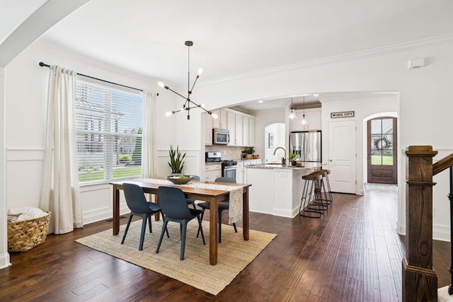 1074 Cantwell Pl, Spring Hill, TN 37174 - dining space with arched walkways, a chandelier, ornamental molding, and dark wood-style flooring