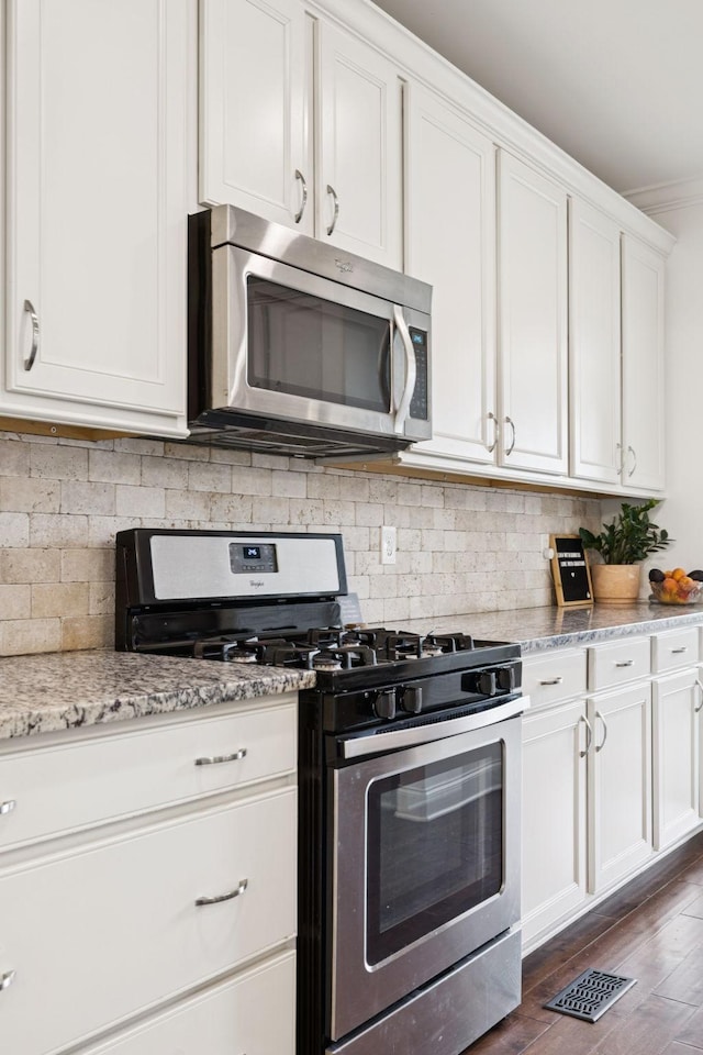 1074 Cantwell Pl, Spring Hill, TN 37174 - kitchen featuring stainless steel appliances, white cabinetry, backsplash, dark wood-style floors, and light stone counters