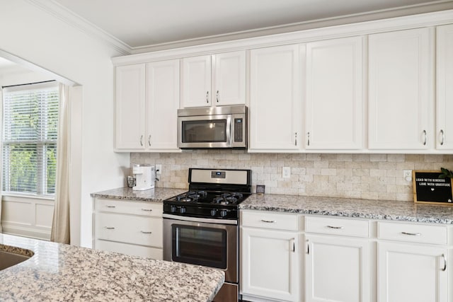 1074 Cantwell Pl, Spring Hill, TN 37174 - kitchen featuring stainless steel appliances, white cabinets, backsplash, light stone countertops, and crown molding