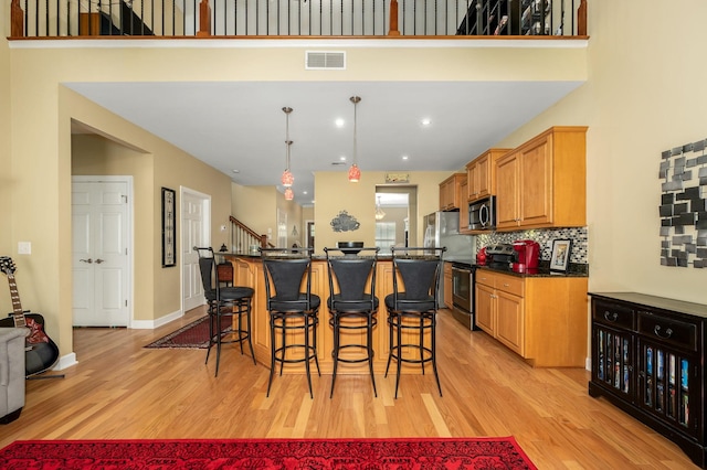 2342 N Tennessee Blvd Unit 601, Murfreesboro, TN 37130 - kitchen featuring appliances with stainless steel finishes, dark countertops, a breakfast bar area, light wood-style flooring, and a center island