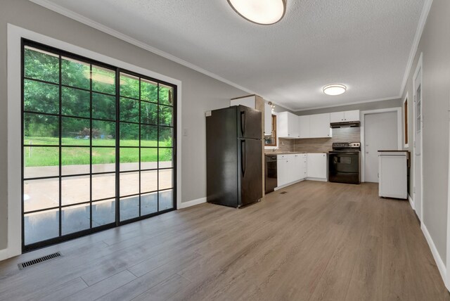 5595 Denmark Rd, Erin, TN 37061 - kitchen with black appliances, light wood-style flooring, crown molding, white cabinets, and under cabinet range hood