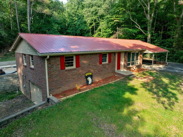 5595 Denmark Rd, Erin, TN 37061 - view of front of home featuring asphalt driveway, brick siding, metal roof, a front yard, and a wooded view