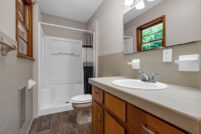 5595 Denmark Rd, Erin, TN 37061 - bathroom featuring tile walls, toilet, wood finished floors, a stall shower, and vanity