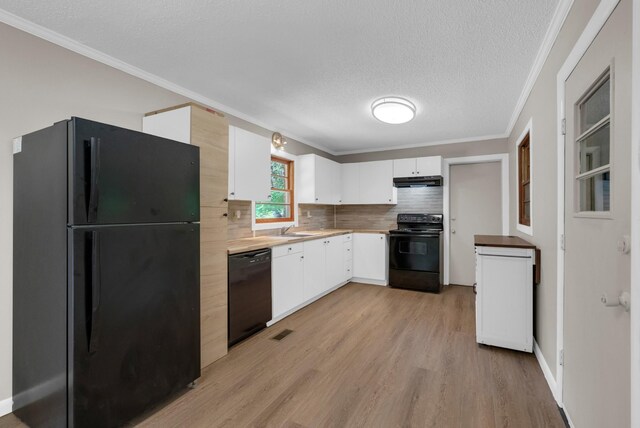 5595 Denmark Rd, Erin, TN 37061 - kitchen with black appliances, under cabinet range hood, a sink, light wood finished floors, and white cabinetry
