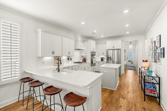 3205 Vinemont Dr, Thompsons Station, TN 37179 - kitchen featuring stainless steel appliances, a sink, custom range hood, a kitchen island, and light wood-style flooring
