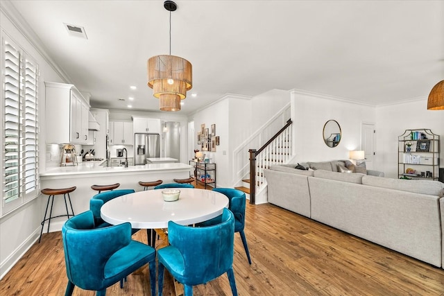 3205 Vinemont Dr, Thompsons Station, TN 37179 - dining room featuring light wood-type flooring, stairway, ornamental molding, recessed lighting, and baseboards