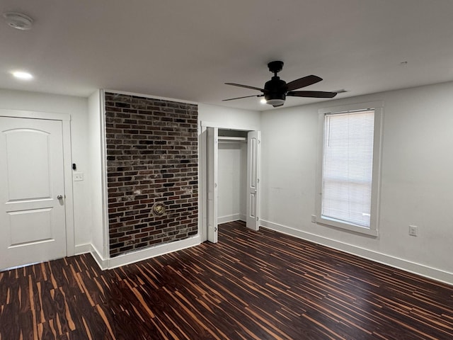 414 Washington St, Columbia, TN 38401 - unfurnished bedroom featuring baseboards, wood finished floors, brick wall, and ceiling fan