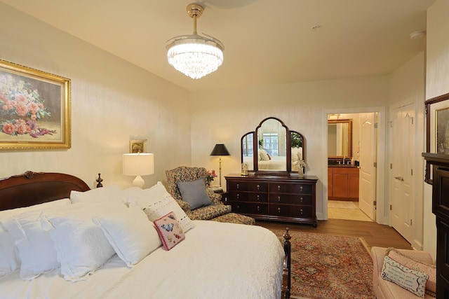 307 Seven Springs Way Unit 304, Brentwood, TN 37027 - bedroom with a chandelier, dark wood-style floors, and ensuite bathroom