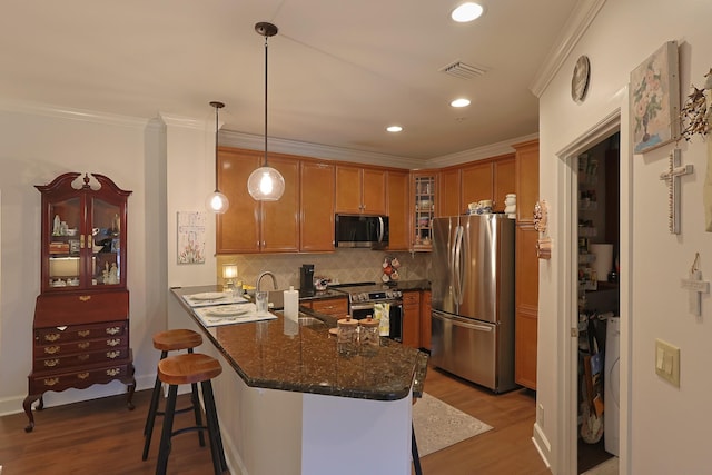 307 Seven Springs Way Unit 304, Brentwood, TN 37027 - kitchen with stainless steel appliances, wood finished floors, a peninsula, decorative backsplash, and a breakfast bar