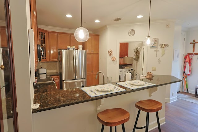 307 Seven Springs Way Unit 304, Brentwood, TN 37027 - kitchen with freestanding refrigerator, washer and dryer, ornamental molding, brown cabinets, and glass insert cabinets