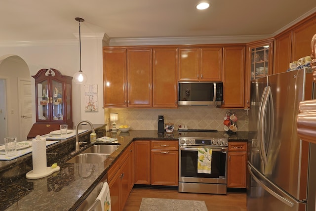 307 Seven Springs Way Unit 304, Brentwood, TN 37027 - kitchen with stainless steel appliances, a sink, wood finished floors, arched walkways, and dark stone countertops