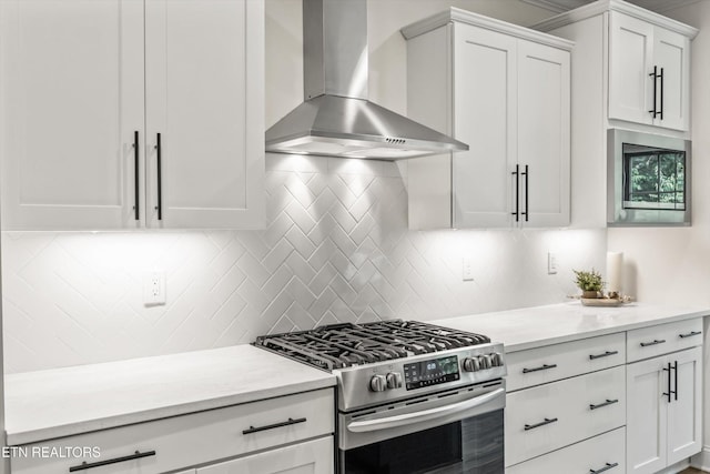 9327 Paradise Valley Ln, Knoxville, TN 37922 - kitchen featuring wall chimney exhaust hood, stainless steel range with gas stovetop, white cabinets, decorative backsplash, and light stone counters