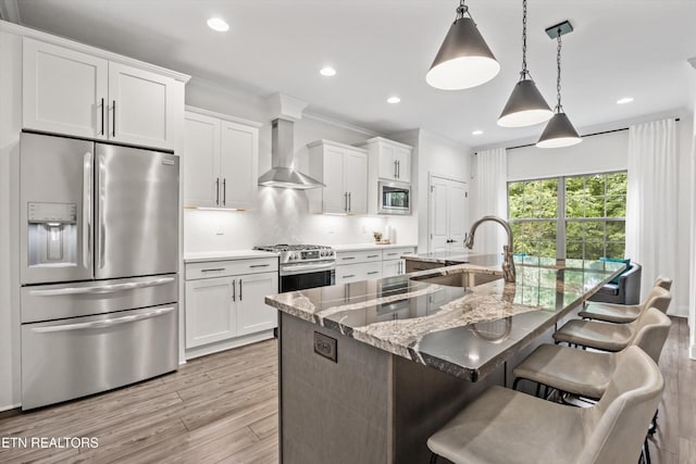 9327 Paradise Valley Ln, Knoxville, TN 37922 - kitchen featuring appliances with stainless steel finishes, wall chimney exhaust hood, white cabinetry, a kitchen breakfast bar, and recessed lighting