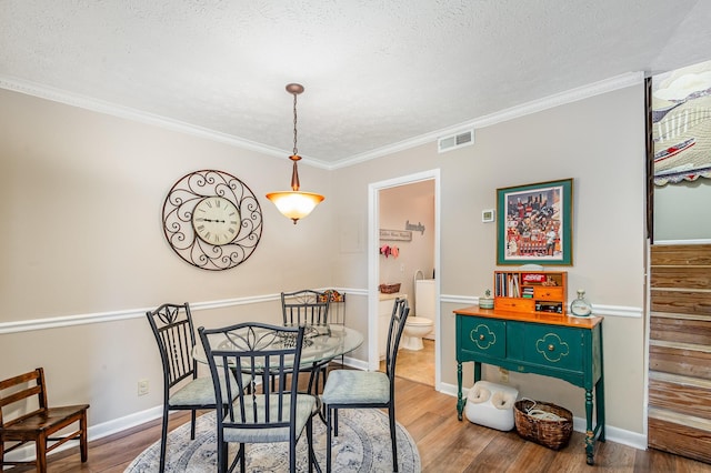 213 Cedarwood Ln, Madison, TN 37115 - dining room featuring wood finished floors, a textured ceiling, ornamental molding, and baseboards